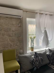 a living room with a couch and a window at Cozy Little House Kotor in Kotor