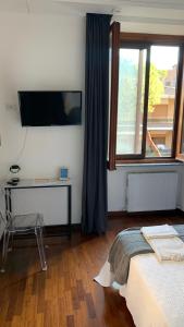 ローマにあるEMI's Guest Houseのベッドルーム1室(ベッド1台、壁掛けテレビ付)