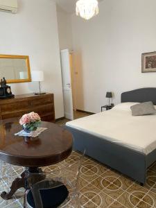 ein Schlafzimmer mit einem Bett und einem Tisch mit Blumen darauf in der Unterkunft Rooms in San Domenico Maggiore 3 in Neapel