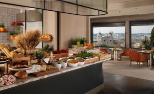 a buffet in a hotel with food on a counter at Hotel Eden - Dorchester Collection in Rome