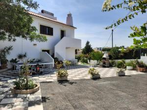 uma casa branca com um pátio com vasos de plantas em Villa Quinta do Algarve em Albufeira