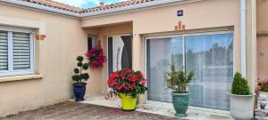 una casa con macetas delante de una ventana en Studio Le Pavachon 2 à 3 couchages, piscine familiale chauffée, 3 min du Puy du Fou Les Epesses, en Les Épesses