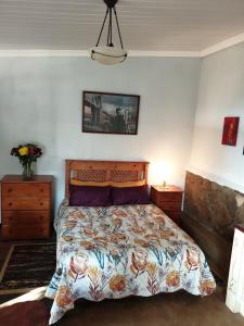 勒斯滕堡的住宿－Dombeya Ridge Guest Suite，一间卧室设有一张大床和两个床头柜