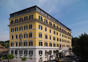 a large building with a clock on the front of it at Hotel Eden - Dorchester Collection in Rome