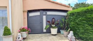 a garage with potted plants in front of a house at Jolie Studio Le Pavachon à 3 min du Puy du Fou Les Epesses in Les Épesses +32 photos