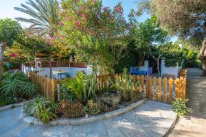 una valla de madera con un árbol en un jardín en Casa de María, en El Palmar