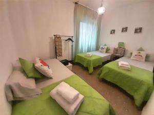 コルドバにあるApartamento Patios de San Lorenzoのベッド2台(緑のシーツ付)が備わる客室です。