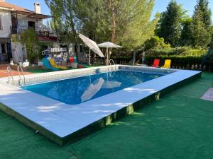 una piscina en un patio trasero con suelo azul y verde en Dos chalets + 3 salones + calefacción + chimeneas (máx 21 personas), en Argés