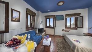 un soggiorno con divano e tavolo con frutta di Hotel Petradi a Kalamaki