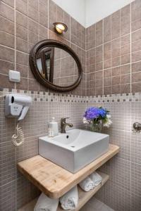 bagno con lavandino bianco e specchio di Hotel Petradi a Kalamaki