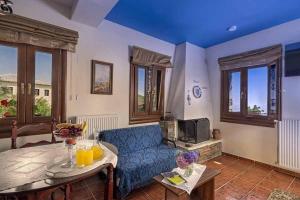 a living room with a blue couch and a table at Hotel Petradi in Kalamaki