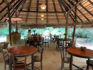 eine Person, die an einem Tisch in einem Restaurant sitzt in der Unterkunft Athreya Ayurveda Ashram in Habarana