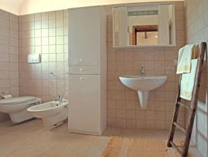 a bathroom with a sink and a toilet and a mirror at Dimora Matarrese B&B Trulli in Alberobello