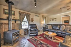 ein Wohnzimmer mit einem Ledersofa und einem Holzofen in der Unterkunft Quiet Cabin with Mtn View and Deck 7 Mi to Navajo Lake in Pagosa Springs