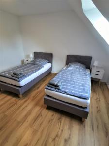 two twin beds in a room with wooden floors at Ferien in Sarstedt am Bruchgraben in Sarstedt