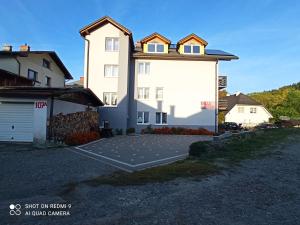 a large white building with a large parking lot at Willa Jacuu in Szczyrk