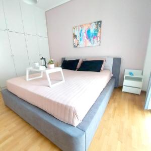 a bed with a white table on top of it at Noelli cozy and modern apartment in Athens