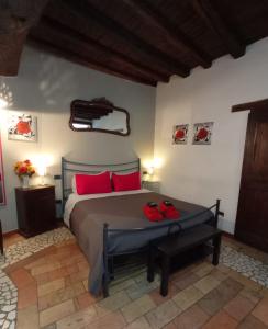 a bedroom with a bed with red pillows and red shoes on it at Casa Paola in Spoleto