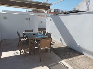 a patio with a table and chairs on a roof at Casa Rural Alcalde Rivera in La Carrasca