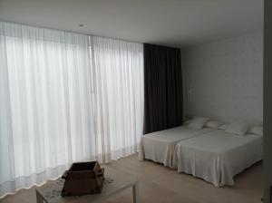 a bedroom with two beds and a large window at Casa Rural Alcalde Rivera in La Carrasca