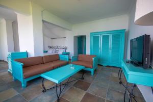 een woonkamer met een bank, een tafel en een tv bij Maris Butik Hotel in Turunc