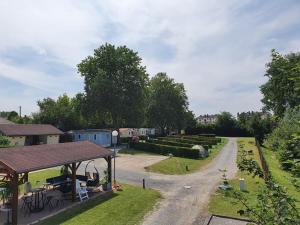 vistas a un jardín con una casa y una carretera en Camping Le Brochet, en Péronne
