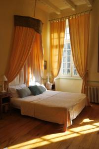 a bedroom with a large bed with orange curtains at La Mouline in Labastide-du-Vert