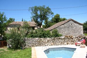 Casa con piscina y pared de piedra en Les Gîtes du Mas d'Aspech en Belmont-Sainte-Foi