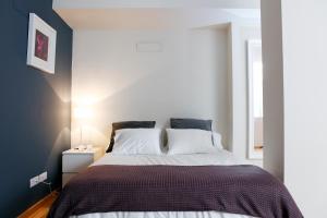 a bedroom with a large bed with black and white sheets at Fira Duplex in Hospitalet de Llobregat