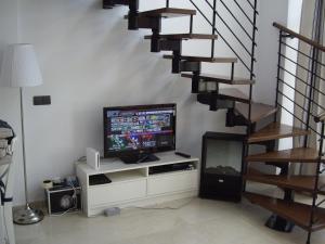a living room with a television and a staircase at Port D'Aro in Platja d'Aro