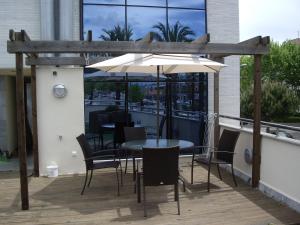 a table with chairs and an umbrella on a balcony at Port D'Aro in Platja d'Aro