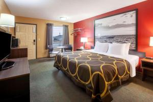 a hotel room with a large bed and a television at Super 8 by Wyndham Sandusky in Sandusky