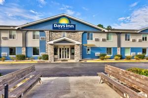 un hotel con panchine di fronte a un edificio di Days Inn by Wyndham Savannah Gateway I-95 a Savannah