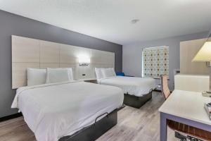 ein Hotelzimmer mit 2 Betten und einem Kamin in der Unterkunft Days Inn by Wyndham Savannah Gateway I-95 in Savannah