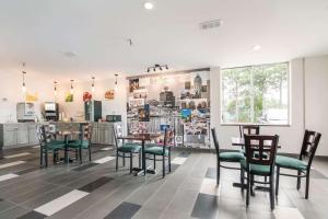 jadalnia ze stołami i krzesłami oraz kuchnia w obiekcie Quality Inn w mieście Rochester