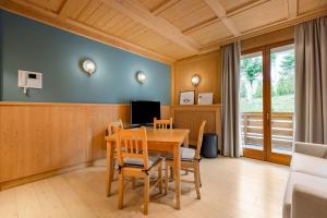 una sala da pranzo con tavolo e sedie in legno di Radisson Residences Savoia Palace Cortina d’Ampezzo a Cortina dʼAmpezzo