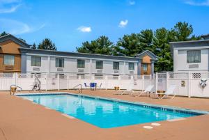 a swimming pool with chairs and a building at Econo Lodge Inn & Suites in Chambersburg