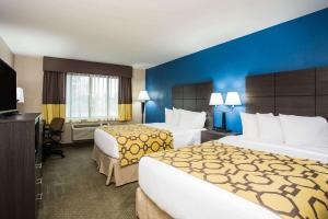a hotel room with two beds and a television at Baymont by Wyndham Appleton in Appleton