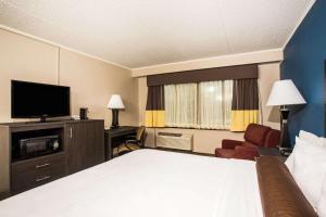 a hotel room with a bed and a flat screen tv at Baymont by Wyndham Appleton in Appleton