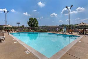 einen Pool in einem Resort mit Stühlen und Sonnenschirmen in der Unterkunft Comfort Inn Nashville West in Nashville