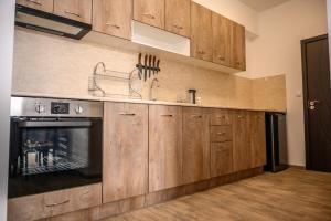 a kitchen with wooden cabinets and a fireplace at Апартаменти ЗДРАВЕ in Sapareva Banya