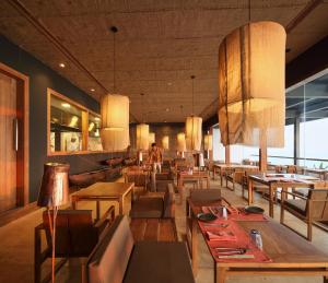 a restaurant with tables and chairs and people in the background at Riff Hikkaduwa in Hikkaduwa