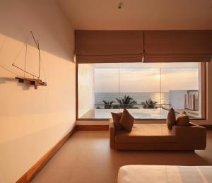 a living room with a couch and a large window at Riff Hikkaduwa in Hikkaduwa