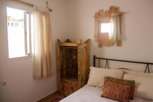 a bedroom with a bed with a wooden cabinet next to a window at Amayour Surf Hostel in Taghazout