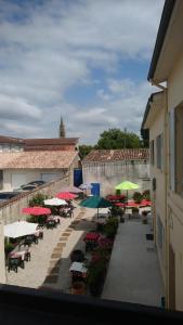 a group of tables and umbrellas in a courtyard at CAFE DE PARIS in Lesparre-Médoc