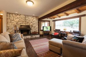 a living room with couches and a stone wall at Hood View 30 Day Minimum cabin in Mount Hood