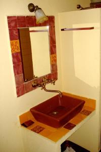 een badkamer met een rode wastafel en een spiegel bij Caserío de Ovejuela in Ovejuela
