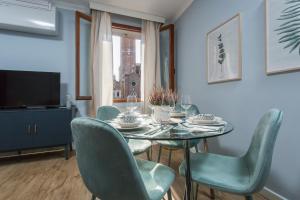 ein Esszimmer mit einem Tisch, Stühlen und einem TV in der Unterkunft Suite Veronica & Maison Laguna in Venedig