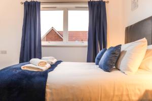 a bedroom with a bed with blue curtains and a window at Cosy - Modern - Accommodation - In Heart of Northumberland in Newbiggin-by-the-Sea