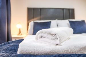 een bed met witte handdoeken erop bij Cosy - Modern - Accommodation - In Heart of Northumberland in Newbiggin-by-the-Sea